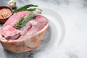 Cut of raw pork knuckle, leg on a table. Farm fresh meat. Gray background. Top view. Copy space