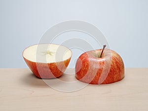 Cut red apple, top and bottom half, side by side