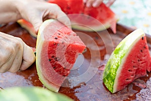 Cut a red watermelon into pieces with a knife