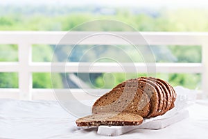 Cut in slices loaf of bread on a cut board on a kitchen background