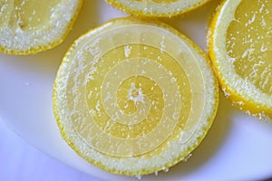 Cut the slices of ripe yellow lemons with sugar
