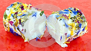 Cut soft white cheese covered in edible flowers.