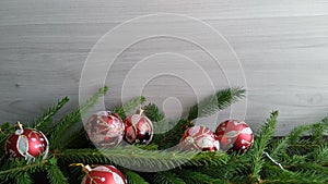 Cut spruce branches with red christmas balls on dark wood background