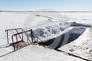 Cut through for swimming. Sunny winter`s day. River landscape