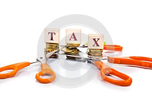 Cut taxes concept with coins and scissors