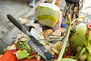 cut a top of coconut to sell refreshing coconut water to tourists.