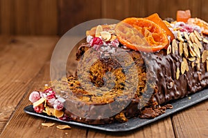 Cut traditional christmas fruit cake pudding in chocolate glaze