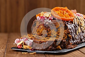 Cut traditional christmas fruit cake pudding in chocolate glaze