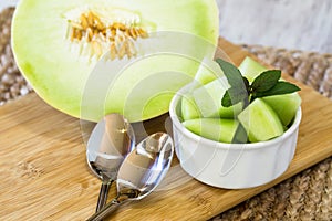 Cut Up Honeydew Melon With Peppermint And Spoons