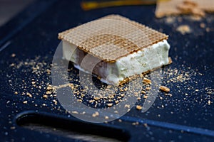 Cut of vanilla, chocolate and cream ice cream next to waffles photo