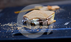 Cut of vanilla, chocolate and cream ice cream next to waffles photo