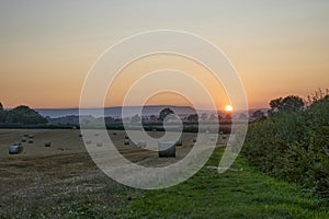 Cut wheat field in Herefordshire countryside at sunset