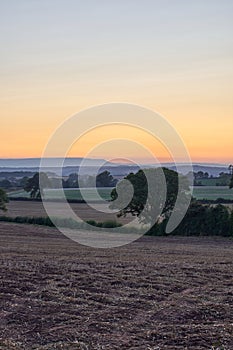 Cut wheat field in Herefordshire countryside at sunset