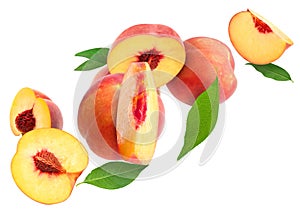 Cut and whole fresh ripe peaches with green leaves falling on white background