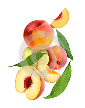 Cut and whole fresh ripe peaches with green leaves falling on white background