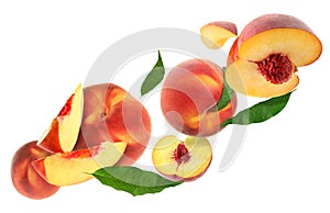 Cut and whole fresh ripe peaches with green leaves falling on white background