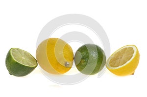 Cut and whole lime and yellow lemons on white background