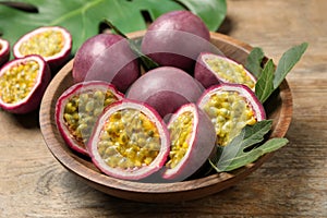 Cut and whole passion fruits on wooden table