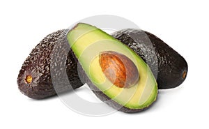 Cut and whole ripe avocadoes on white background