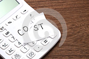Cut the word cost concept for recession or credit crisis and calculator on wood. Concept of cost cut.