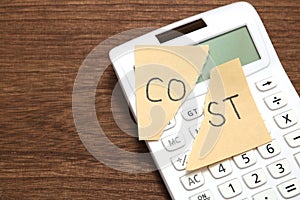 Cut the word cost concept for recession or credit crisis and calculator on wood. Concept of cost cut.