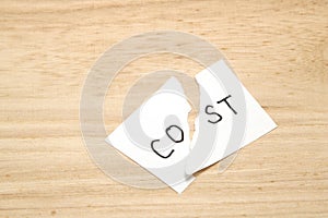 Cut the word cost concept for recession or credit crisis on wood.