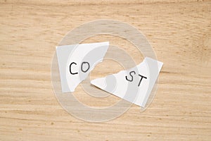 Cut the word cost concept for recession or credit crisis on wood.