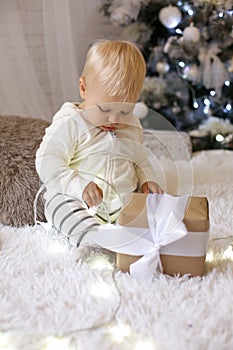 Cute 1 year old baby boy in cozy clothes, posing in New Year dec