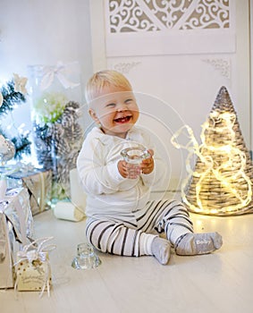 Cute 1 year old baby boy in cozy clothes, posing in New Year dec