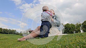 Cute 1 year old baby boy playing with mother on grass at park