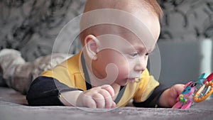 Cute 5 month old baby boy, playing with a teething toy.