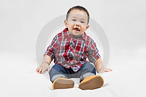 Cute 6-7 months little asian baby boy in casual outfit and baby boots sitting on white blanket cool and happily at home,Stylish