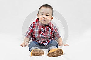 Cute 6-7 months little asian baby boy in casual outfit and baby boots sitting on white blanket cool and happily at home,Stylish