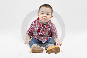 Cute 6-7 months little asian baby boy in casual outfit and baby boots sitting on white blanket cool and happily at home,Stylish
