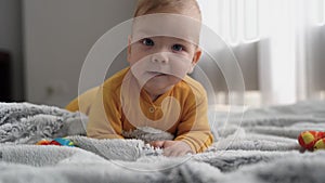 Cute 6 month old baby boy smiling, playing and crawling on the floor. Early childhood development concept.