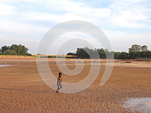 Cute Aboriginal child running all excited towards the water at Rapid Creek. Darwin NT Australia.