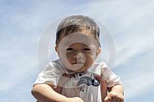 Cute and adorable Asian Chinese baby boy carry up by mother