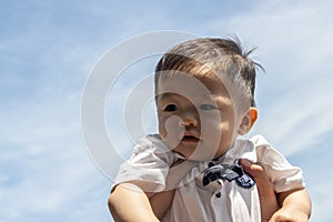 Cute and adorable Asian Chinese baby boy carry up by mother