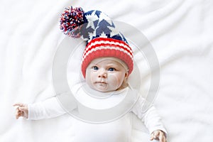 Cute adorable baby child with Christmas winter cap on white background. Happy baby girl or boy smiling and looking at