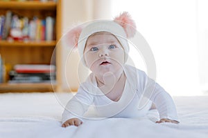 Cute adorable baby child with warm white and pink hat with cute bobbles