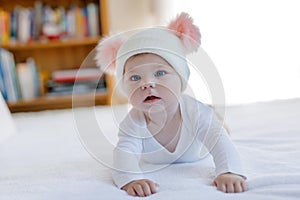 Cute adorable baby child with warm white and pink hat with cute bobbles