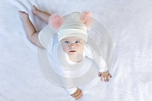 Cute adorable baby child with warm white and pink hat with cute bobbles