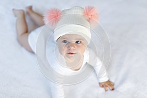 Cute adorable baby child with warm white and pink hat with cute bobbles