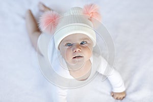 Cute adorable baby child with warm white and pink hat with cute bobbles