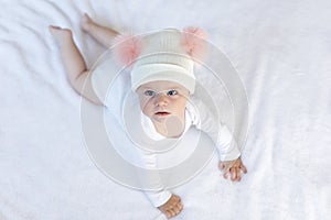 Cute adorable baby child with warm white and pink hat with cute bobbles