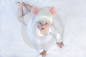 Cute adorable baby child with warm white and pink hat with cute bobbles