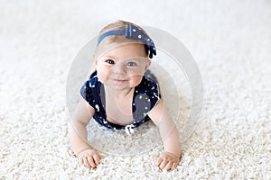 Cute adorable baby girl in blue clothes and headband.