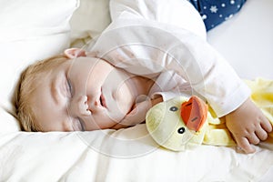 Cute adorable baby girl of 6 months sleeping peaceful in bed