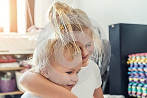 Cute adorable blond caucaian little sister hugging her toddler brother.couple of cheerful sibling playing indoor. Cute