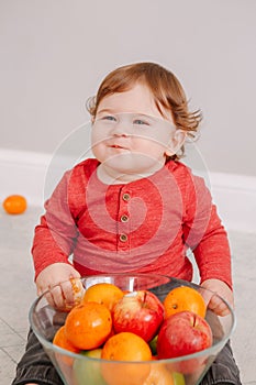 Cute adorable Caucasian baby boy eating citrus fruit. Finny child eating healthy organic seasonal summer snack meal. Solid finger